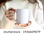 Girl in white sweater holding white coffee mug  , white porcelain mug mock up 