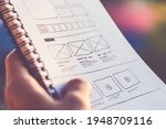 Designer Holding a Notebook with Web Site Wireframes Layout  Photo
