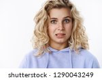 Small photo of Girl feeling awkward and sorry as confessing in making mistake hum and haw with sorrow and reluctance standing intense and distressed, looking worried or nervous as posing in hoodie over white wall