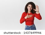 Small photo of Promise tell truth. Charming happy relaxed sincere young curly-haired girl pleadging oath swear hold hand heart raise palm making statement smiling happily, standing white background