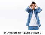 Portrait of asian man in panic, have big problem, dont know what to do, react terrible situation, anxiously staring camera, gasping hold hands on head, standing alarmed white background