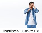 Small photo of Oh my god what should I do. Shocked and concerned asian guy in panic grab his face and staring camera indecisive, standing alarmed got in terrible situation, have big problem, white background