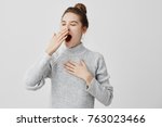 Tired woman yawning covering open mouth with hand need rest. Young female worker being sleepy head can't wake up having insomnia. Chain reaction