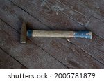 wood and rust head iron hammer lying on wooden board with outdoor workshop. High quality photo