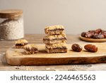 Small photo of Homemade old fashioned date squares or Matrimonial bars on wooden cutting board with ingredients