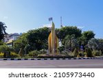 The pointed bamboo monument (monumen bambu runcing) is surrounded by fountains and trees which is located in the middle of Surabaya city street. Taken during the day