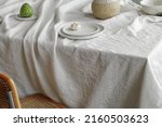 Small photo of Elegant table setting with cherimoya fruits, garlic in craft ceramic plate on linen tablecloth. Outdoor table setting for summer holiday concept.
