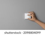 Small photo of Woman Hand Adjusting or Turning On Off Wall Temperature Regulator Controller Button