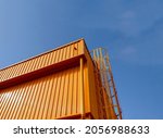 Small photo of The building is constructed with metal sheet material. painted in yellow throughout with a background of a blue sky during the day.