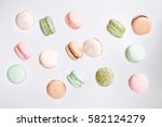 Colorful macarons cake, top view flat lay, fly falling sweet macaroon on color white isolated background. Minimal concepts falling macaroons pattern above, food natural background