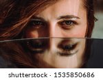 Small photo of Woman eyes close up reflected in mirror. Hypnotize strong look. Hypnotic deeply penetrating glance. Revengeful insidious expectant gaze. Young caucasian girl face. Horizontal portrait. Good vision