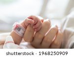 new born baby hand hold mum index finger. concept : Premature or preterm baby in hospital. relationship between mother and baby.