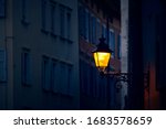 Victorian vintage street lantern with yellow warm light at the evening on the italian mysterious street by night