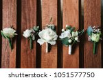Top view of wedding boutonniere for the groom and bridesmaids on wooden background, free space. Wedding details outdoor with copy space. Wedding morning preparation
