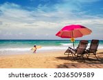 Pink Umbrella two chairs shoreline island Brazil. Surfboard person tropical seaside summer Italy. Landscape wide Blue sea sky travel trips famous beach Spain.