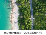 Car driving tropical beach road trips holiday. Top view drone urban street road seaside during sunset. Most green coconut trees wood summer famous landmark in Phuket,Thailand. copy space 2022