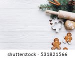 Christmas border. Gingerbread cookies, spices and decorations on white wooden background.