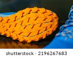 Small photo of The shoes are laid out on reflective soles and a pair of blue laces are seen on the front, Orange tread soles for trail running. The sole is very thick for wading on smooth roads and muddy roads.