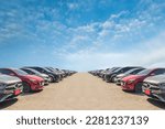 Lot of used car for sales in stock with sky and clouds