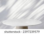 Small photo of Round marble table top with tree leaves shadow drop on white wall background for mockup product display