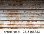 Small photo of Rust and corrosion in the shutter. Corrosive Rust on old iron.Use as illustration for presentation. Rusted iron shutter, Brown and yellow wet rust and dirt on white enamel. Iron rusted iron plates.