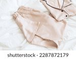 Ladies pajamas on bed. Pajama in shop top view. Advertise, sale, fashion and shopping concept.