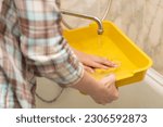 Small photo of woman washing cat litter box in bathroom. cat litter cleaning