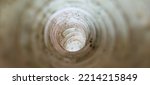 Small photo of Deep white large and long dirty flexible endless round plastic pipe hole inside closeup view. Pipeline, tube, duct, drainage, sewage, sewer and mine concept. Abstract blurry background with copy space