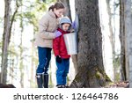 Small photo of two children looking in a sap bucket at a sugar bush