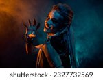 Small photo of Profile photo of merciless furious valkyrie woman grin teeth arm scare orange blue lights isolated on dark background