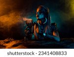 Small photo of Portrait of dangerous valkyrie druid woman hold potion cup blue yellow light fog isolated on black color background