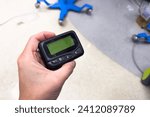 Small photo of vintage pager on a busy desk, symbolizing hectic work life and essential communication in a hospital setting