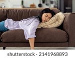 Small photo of Tired caucasian young woman falls asleep on couch on the couch after hard working day, fatigue concept