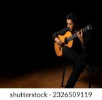 Hispanic man playing guitar ...