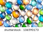 Small photo of Plenty agleam multicolored glass balls or marbles mix on white background, color beads with reflections, abstract in horizontal orientation, nobody.