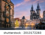 Old Town Square in the early morning with Astronomical Clock in the foreground and Tyn Temple with christmas tree in the background in Prague during Christmas time.