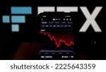 Small photo of Munich, Germany; November 12, 2022: A man holds an iPhone XR on which the price of the token FTT from the crypto exchange FTX is displayed