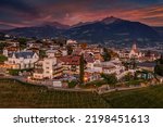 Tirol, Italy - Aerial view of Tirol (Dorf Tirol), a comune located at the northwest of the city of Bolsano at sunset with beautiful sky and clouds, vineyards and Italian Dolomites at background
