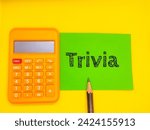 Small photo of A picture of a paper, calculator, and pencil has the word "Trivia" written on a yellow background. Business themed picture concept.