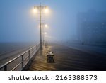 Small photo of Street lights, foggy misty night, lamp post lanterns, deserted road in mist fog