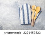 Wooden kitchen utensils, potholder and glove on the table, top view. Kitchen Mitten, oven mitt and wooden cutlery on a gray marble table. Kitchen accessories.Kitchen concept.