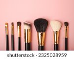 Cosmetic makeup brush on a pink background. Cosmetic product for make-up. Creative and beauty fashion concept. Fashion. Collection of cosmetic makeup brushes, top view, banner.Place for text. MOCAP.