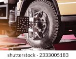 Small photo of Yogyakarta, Indonesia - July 17, 2023: Car wheel clamp with wheel align device for wheel alignment truck tire in workshop
