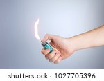Hand burning a lighter on white ...