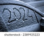 Small photo of close-up snow on the car where the numbers are written 2024, textured snowy background