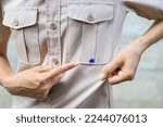 Small photo of Hand showing dirty blue ink stain on shirt from accident in using pen in daily life. selective focus. stain for cleaning concept.