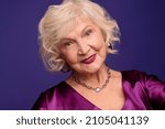 Senior blonde woman in an evening violet dress looking wonderful
