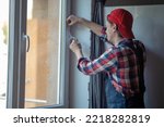 Skilled Caucasian serviceman weather-stripping the home window