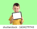 Small photo of Happy child boy holding a tablet ipade for your information on the Aqua Menthe background
