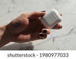 close-up photo of person holding airpods casing